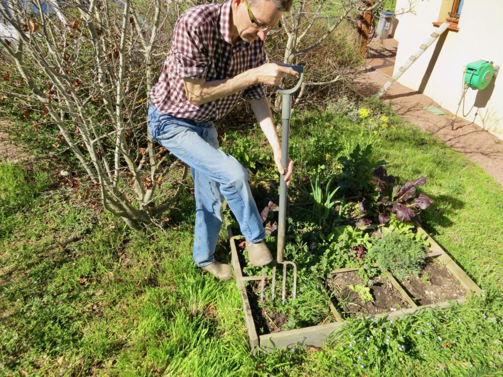 Nicolas en train d'aérer un potager en carrés